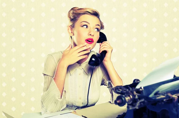 Mujer retro hablando por teléfono junto a una máquina de escribir